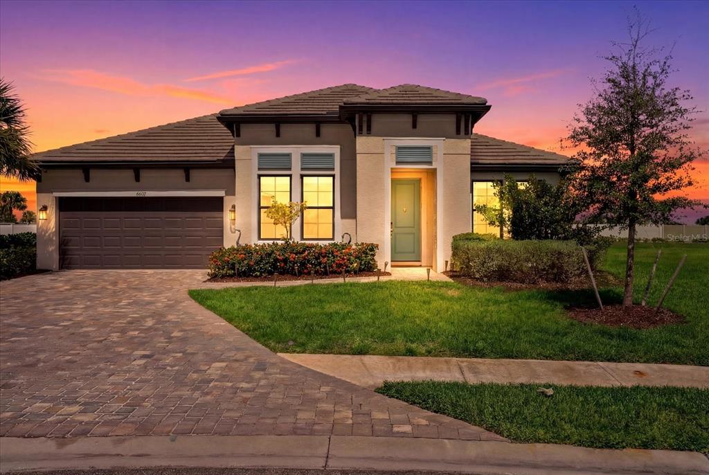 A single-story house with a paved driveway, a two-car garage, and a light-colored front door — 4607 RAINWATER GLEN, BRADENTON, FL