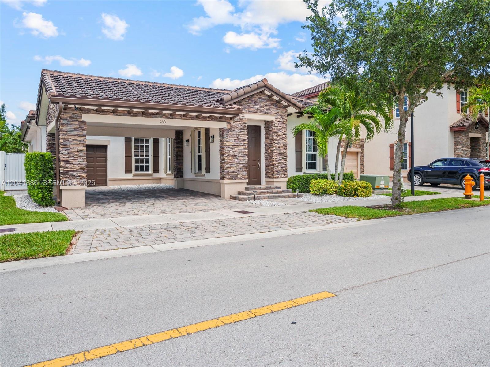 A single-story house with a stone facade, a tiled roof, and a covered carport — 9171 SW 172nd Ave, Miami FL 33196, MIAMI, FL