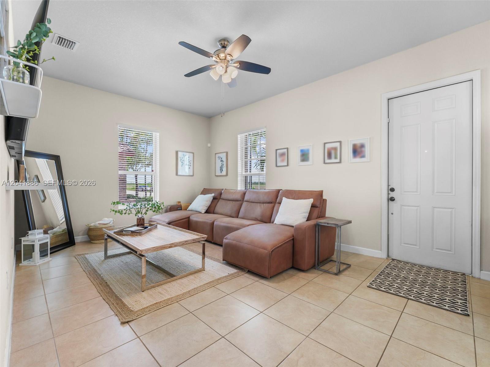 A living room features a brown sectional sofa, a coffee table, and a ceiling fan — 9171 SW 172nd Ave, Miami FL 33196, MIAMI, FL