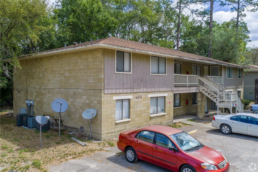 An exterior view of a two-story apartment building with a parking lot in front — 6816 SW 4TH PLACE, GAINESVILLE, FL
