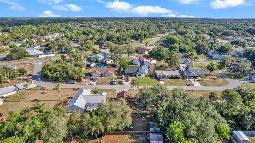 An aerial view shows a suburban neighborhood with houses, trees, and paved streets — 4845 HAWLEY ROAD, COCOA, FL