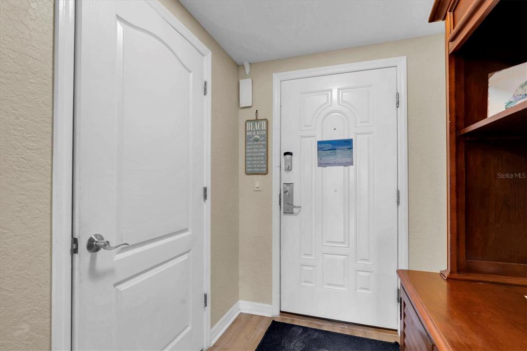 An entryway features a white door, a closed interior door, and a wooden cabinet — 12000 GULF BOULEVARD UNIT 207N, TREASURE ISLAND, FL