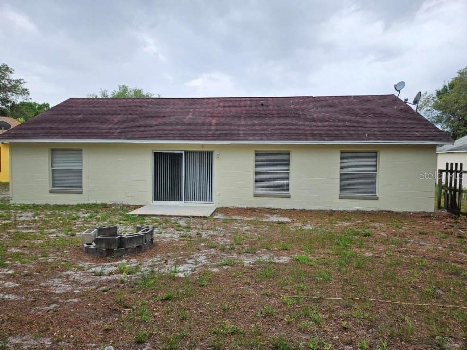 The exterior of a single-story house with a concrete block wall and a sliding door — 9687 LINGWOOD TRAIL, ORLANDO, FL
