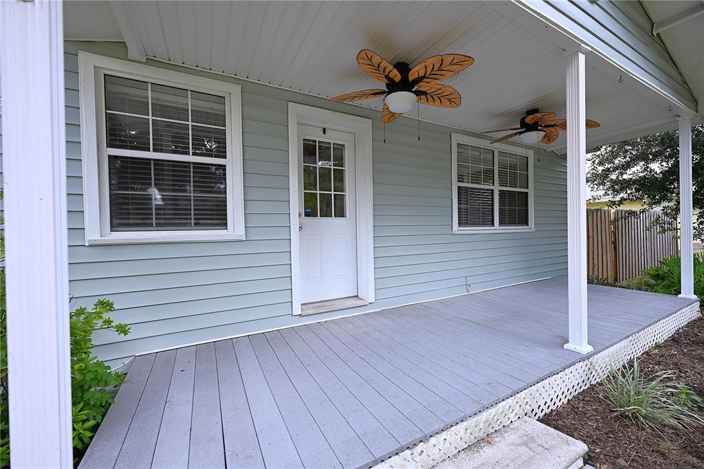 A light blue house features a covered front porch with two leaf-shaped ceiling fans — 3958 2ND STREET NW, LAKELAND, FL