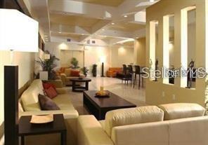 A living room features light-colored sofas, a dark coffee table, and recessed wall niches — 701 S MADISON AVENUE UNIT 215, CLEARWATER, FL
