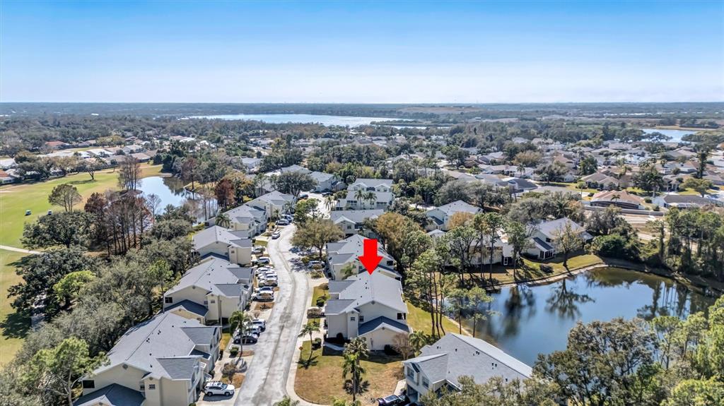 A screened-in porch with white tile flooring and a ceiling fan overlooks a pond — 5430 FAIR OAKS STREET UNIT 5430, BRADENTON, FL