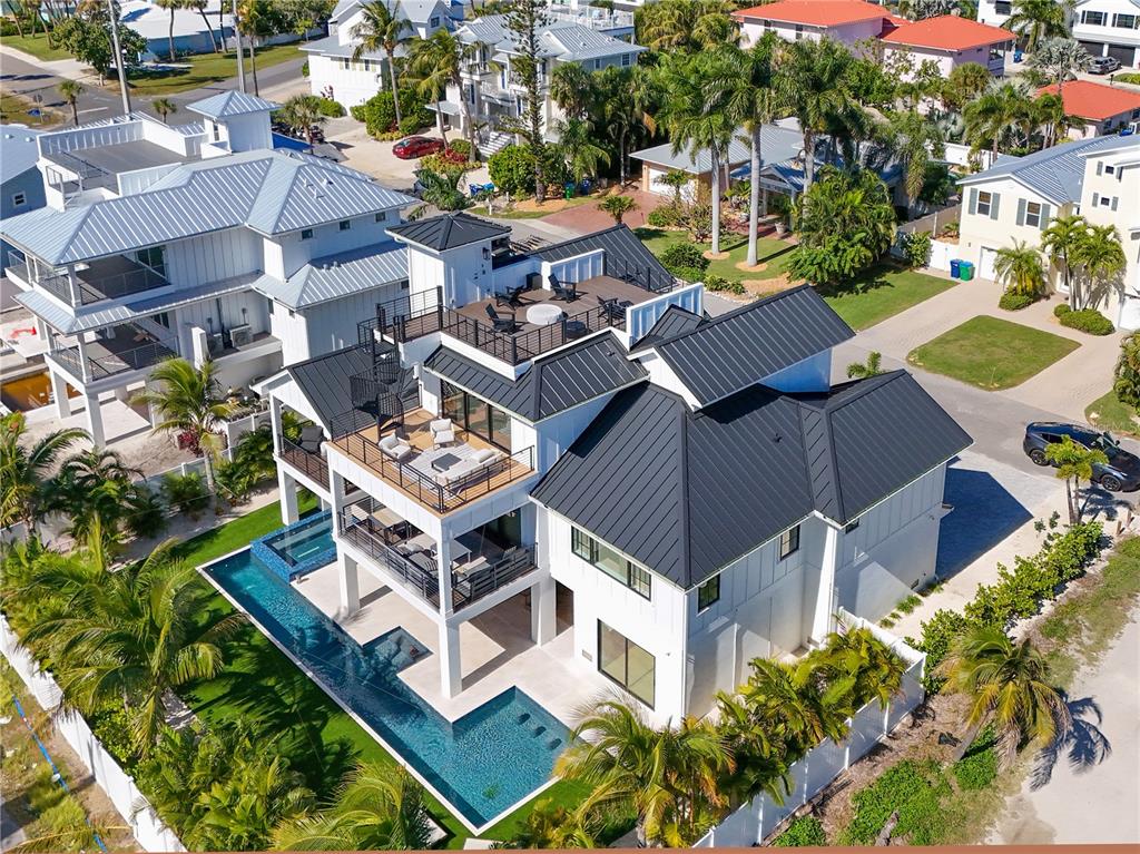 An aerial view of a multi-story white house with a black metal roof and pool — 305 55TH STREET, HOLMES BEACH, FL
