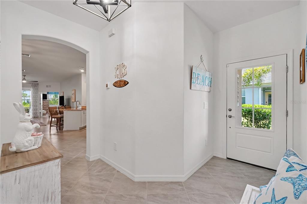 A bright entryway features tile flooring, a white front door, and an arched doorway — 17848 PALMETTO PASS LANE, PUNTA GORDA, FL