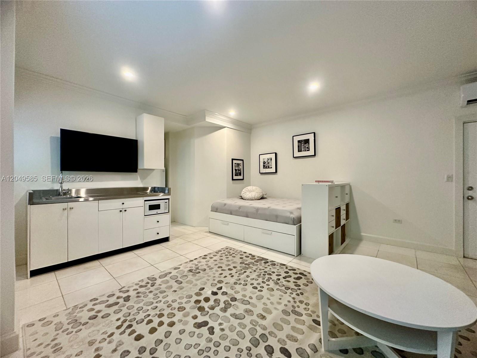 A studio apartment features a kitchenette, a bed with storage, and a patterned area rug — 260 Euclid Ave # 6, Miami Beach FL 33139, MIAMI BEACH, FL