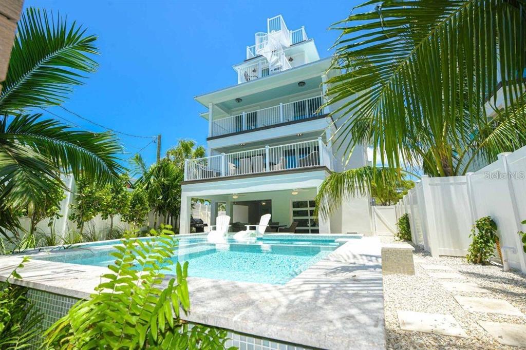 A multi-story house with balconies and a spiral staircase overlooks a backyard swimming pool — 332 AVENIDA DE MAYO, SARASOTA, FL