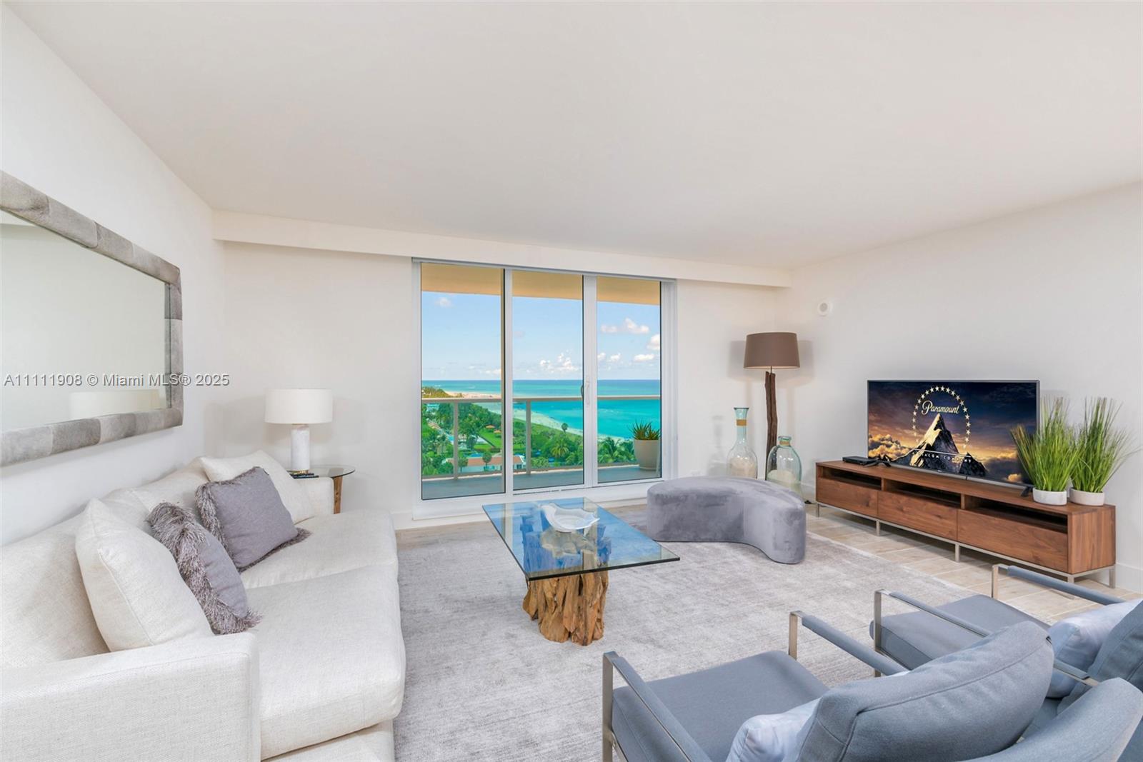 A living room features a white sofa, glass coffee table, and a balcony with ocean views — 102 24th St # 1019, Miami Beach FL 33139, MIAMI BEACH, FL