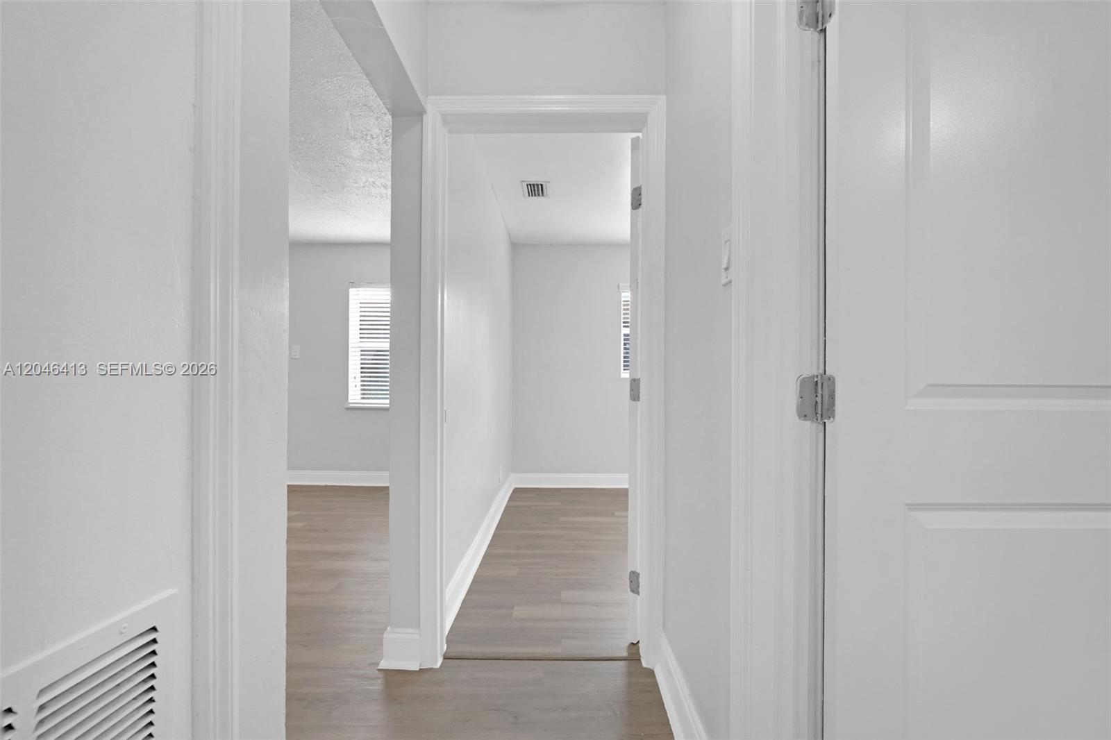 A hallway leads to two rooms with light-colored walls and wood-look flooring — 746 SW 4th St, Dania Beach FL 33004, DANIA BEACH, FL
