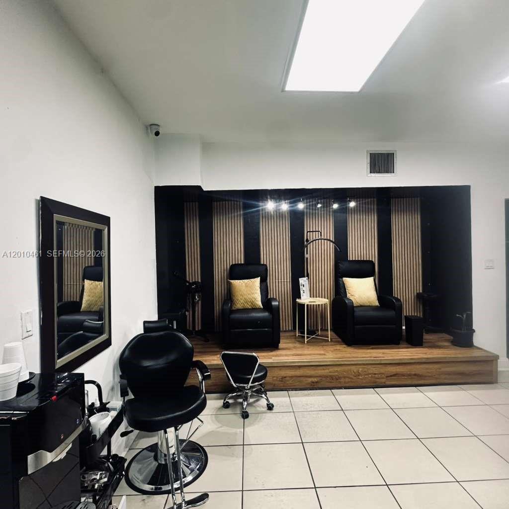 A salon interior features a raised wooden platform with two black chairs and slatted walls — 9610 Fontainebleau Blvd, Miami FL 33172, MIAMI, FL