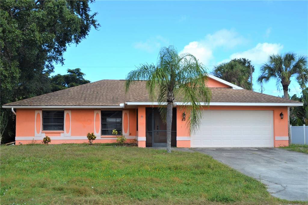 A single-story peach-colored house with a two-car garage and a front palm tree — 88 TEMPLE ROAD, VENICE, FL