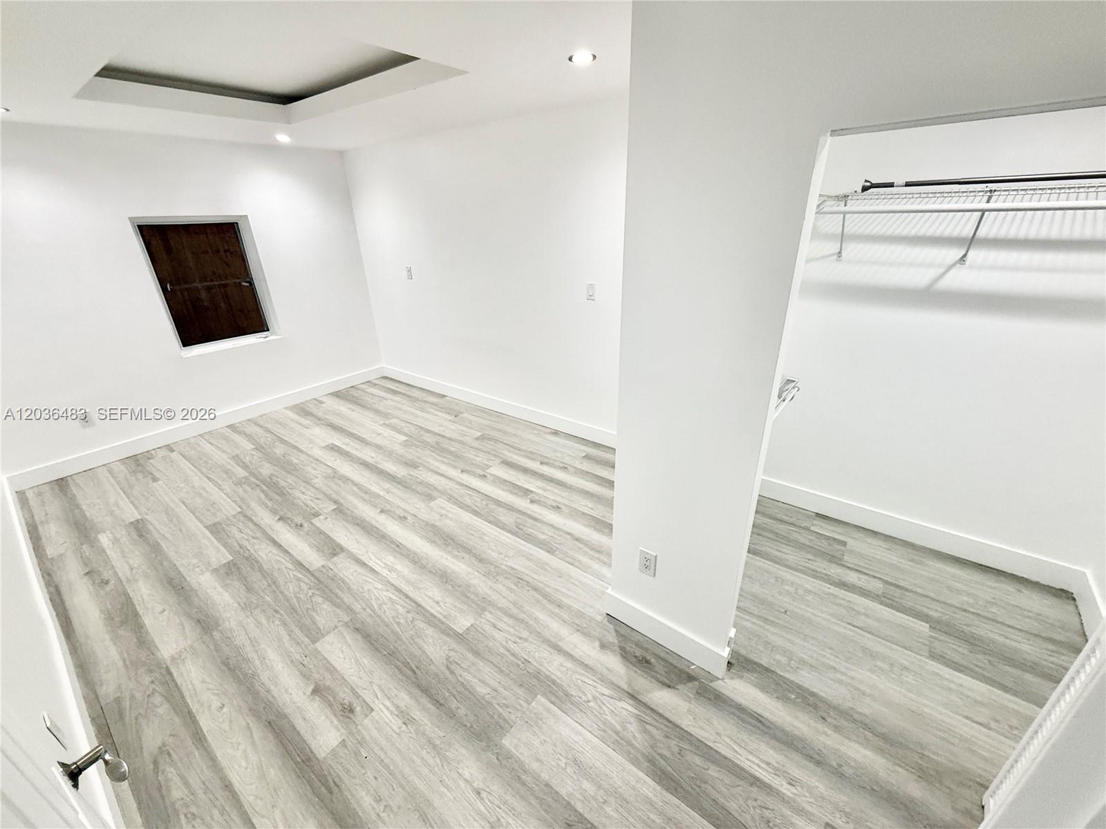 A room with light wood-look flooring, white walls, a small window, and an open closet — 1272 NE 145th St, Miami FL 33161, MIAMI, FL
