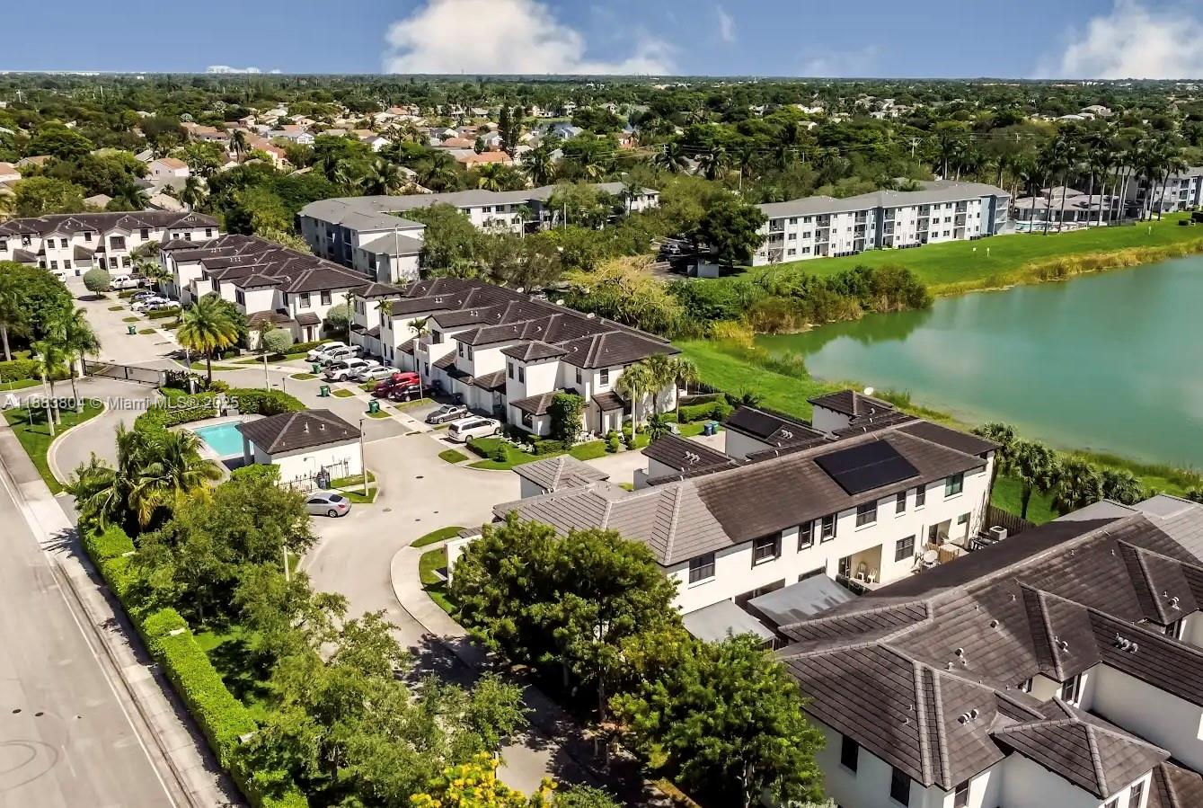 An aerial view shows a residential complex with townhouses, a swimming pool, and a lake — 22509 SW 102nd Ave, Miami FL 33190, MIAMI, FL