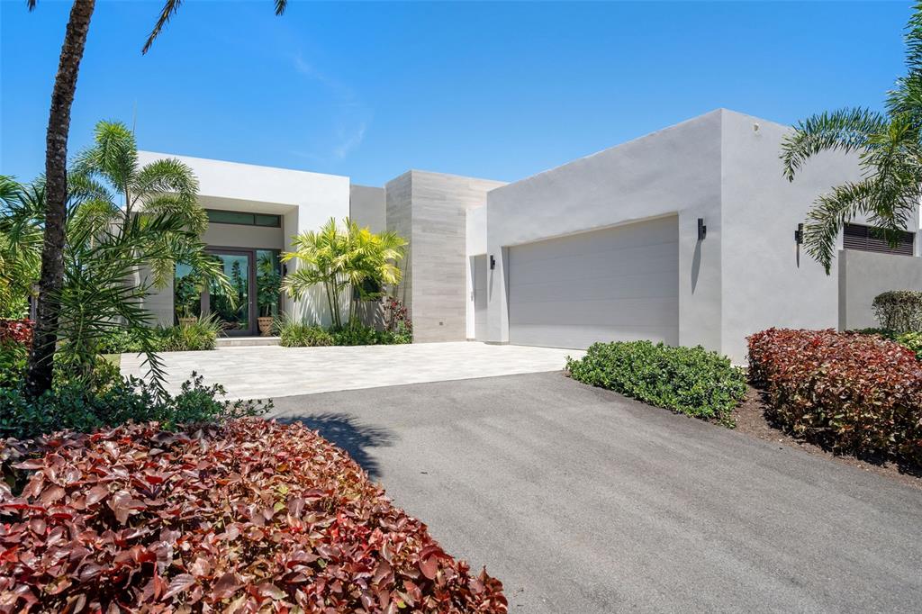A modern white house with a flat roof, a two-car garage, and tropical landscaping — 32 THE ISLES, DORADO, PR