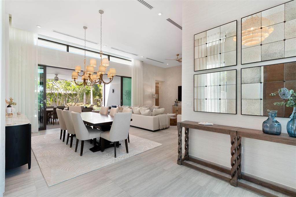 A dining area and living room feature a chandelier, tiled floors, and a console table — 32 THE ISLES, DORADO, PR