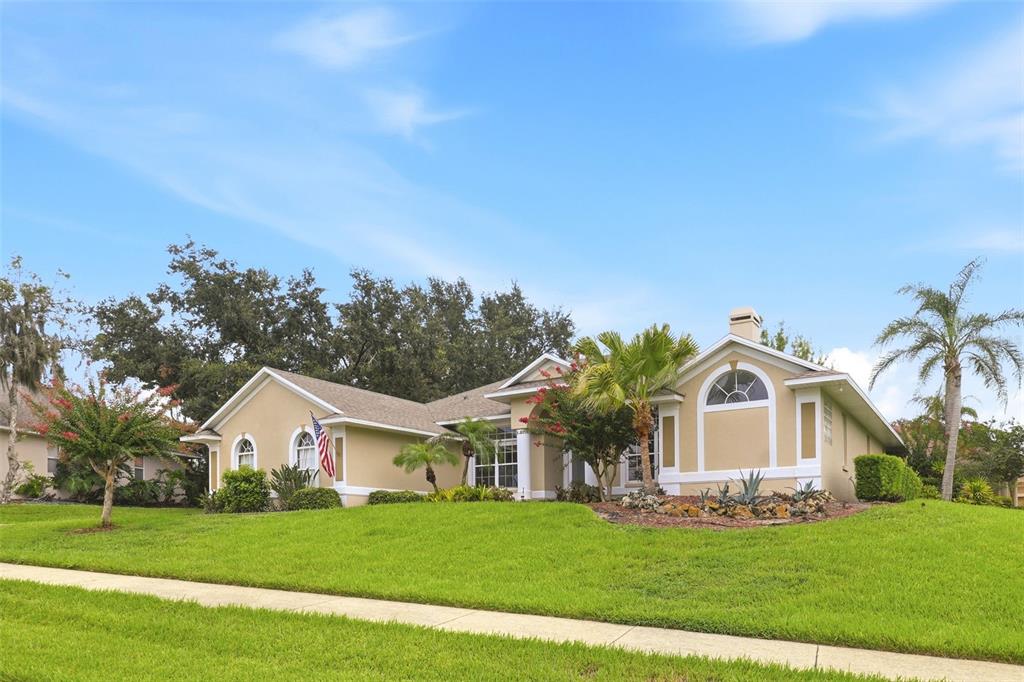 A tan single-story house with a gabled roof and a large front lawn — 11310 SUSANS POINT DRIVE, CLERMONT, FL