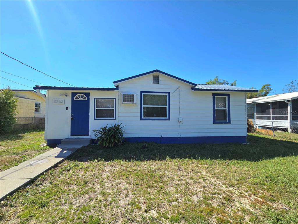 A single-story house with white siding, a blue door, and a metal roof — 2253 & 2249 GOLFVIEW STREET, LAKELAND, FL