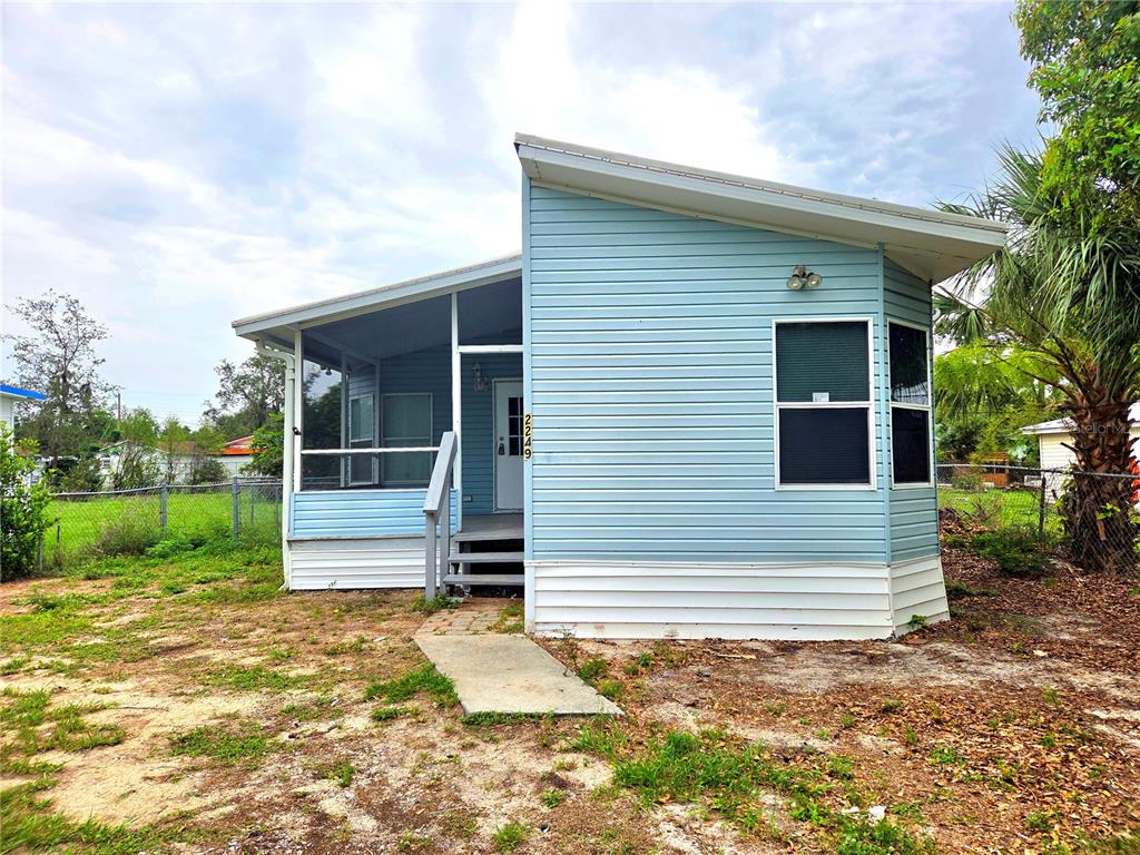 A light blue mobile home features a screened-in porch and a slanted roof — 2253 & 2249 GOLFVIEW STREET, LAKELAND, FL