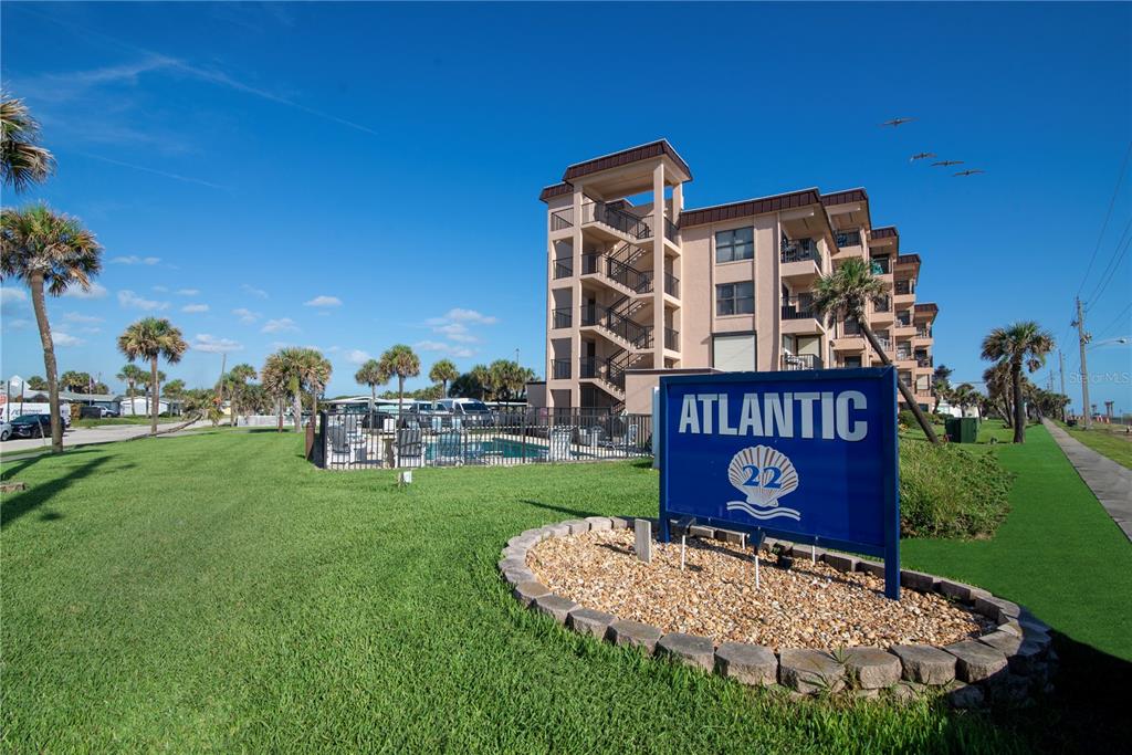 A blue sign for Atlantic 22 stands in front of a multi-story apartment building — 2390 OCEAN SHORE BOULEVARD UNIT 1040, ORMOND BEACH, FL