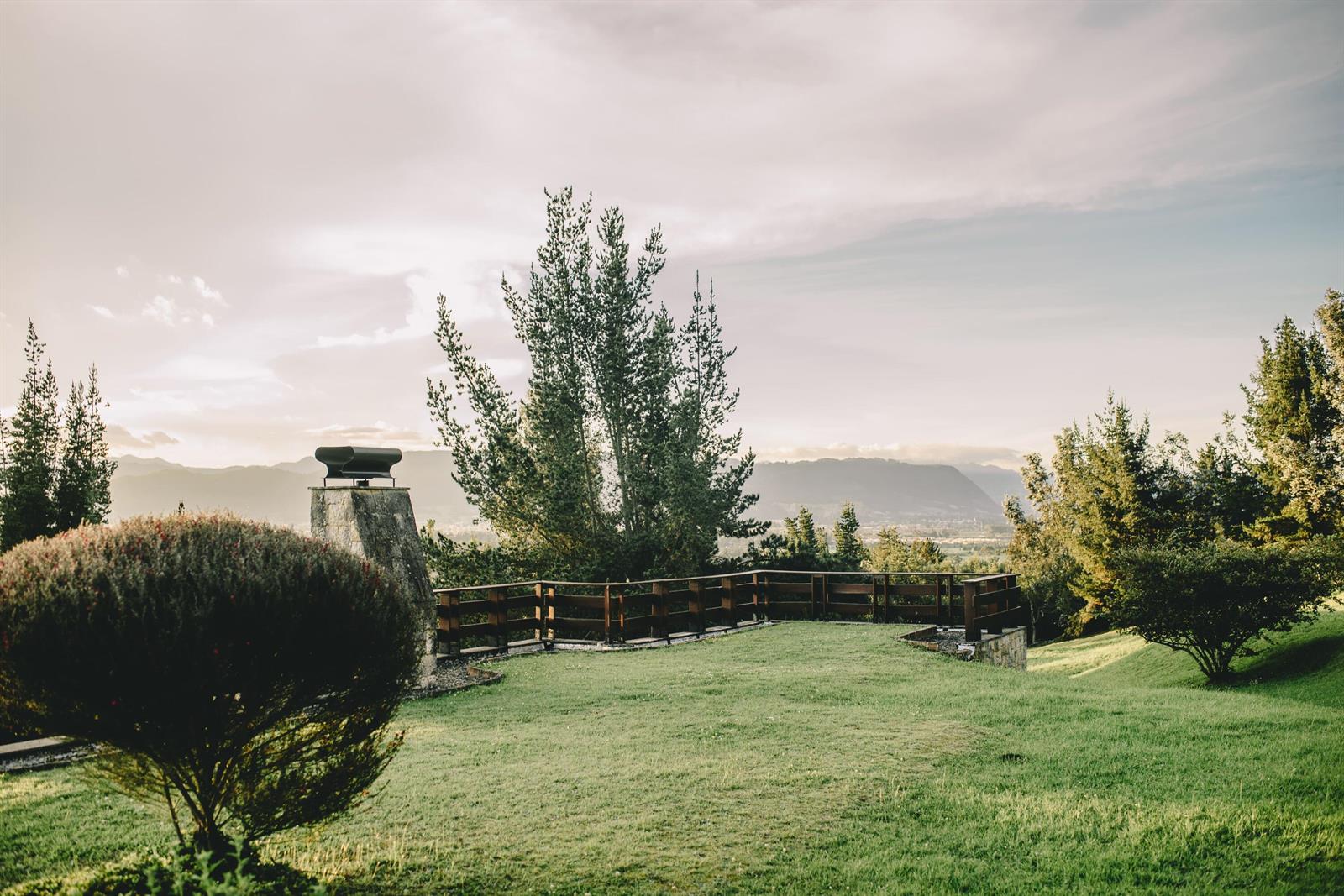 A grassy backyard features a stone chimney, a wooden fence, and a scenic mountain view — 43 Altos De Yerbabuena # 43, FL
