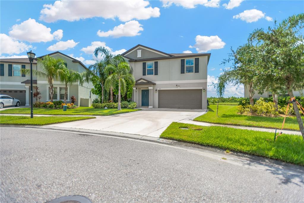 A two-story suburban house with a gray exterior, a two-car garage, and a concrete driveway — 5441 RAINWOOD MEADOWS DRIVE, APOLLO BEACH, FL