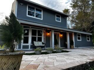 A two-story blue house with a stone patio and a covered front porch — 4332 145th Avenue N, FL 33470, FL