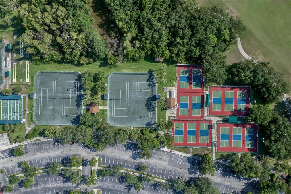 Aerial view of a recreational facility featuring multiple tennis and pickleball courts near a parking lot — 1192 VIA GALUPPI STREET, KISSIMMEE, FL