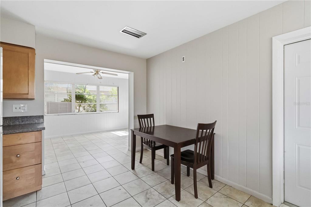 A dining area with a dark wood table and chairs sits on light tile flooring — 308 LANTANA AVENUE, SARASOTA, FL