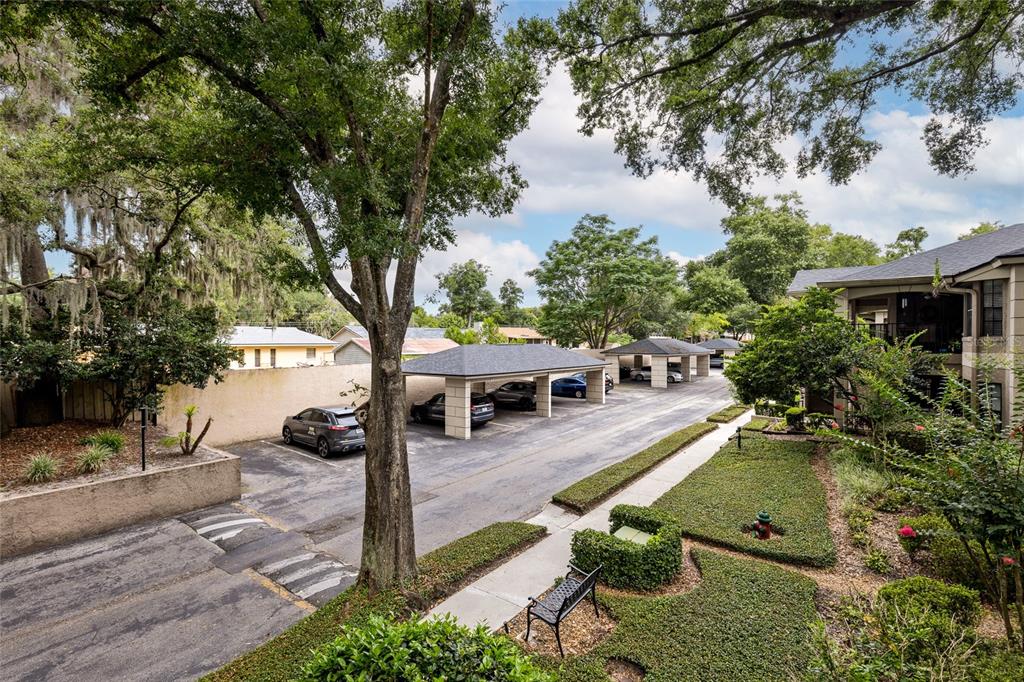 An elevated view of a parking lot with covered carports and surrounding landscaping — 1055 KENSINGTON PARK DRIVE UNIT 613, ALTAMONTE SPRINGS, FL