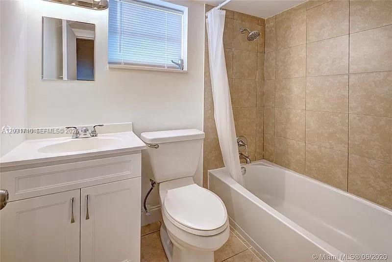 A bathroom features a white vanity, a toilet, and a shower-tub combination with tiled walls — 4121 NW 26th St # T14, Lauderhill FL 33313, LAUDERHILL, FL