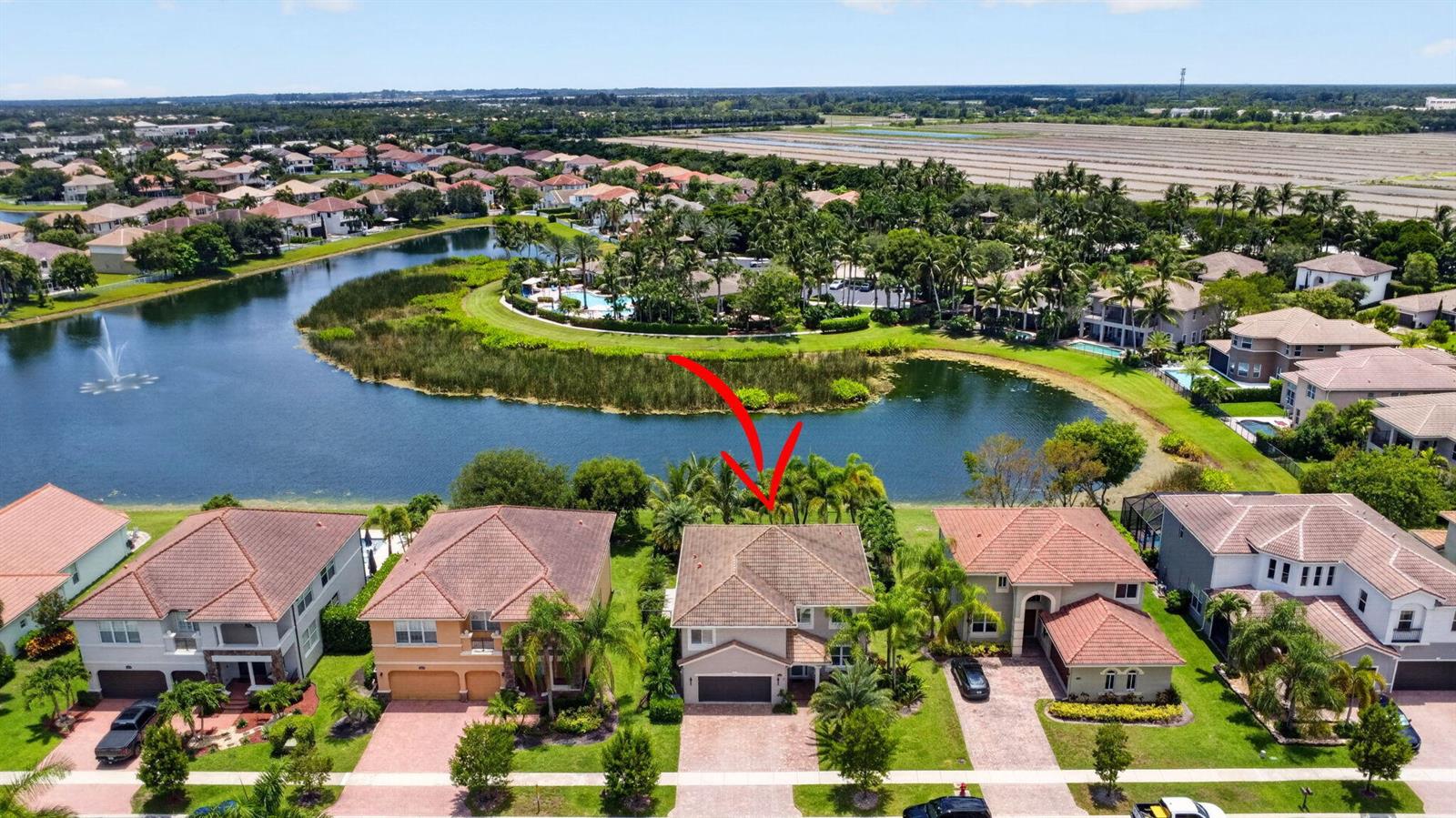 An aerial view of a two-story suburban house with a tile roof facing a lake — 8890 Cobblestone Point Circle, Boynton Beach FL 33472, BOYNTON BEACH, FL