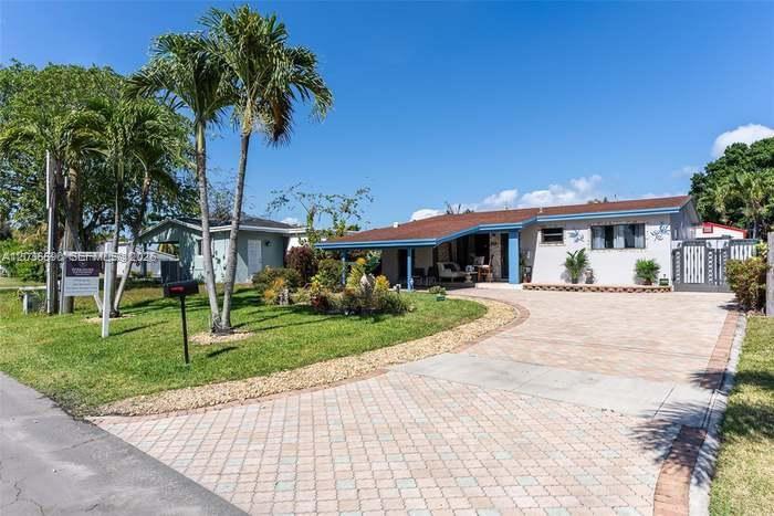 A single-story house with a paved driveway and palm trees in the front yard — 707 SW 3rd Ave, Hallandale Beach FL 33009, HALLANDALE BEACH, FL