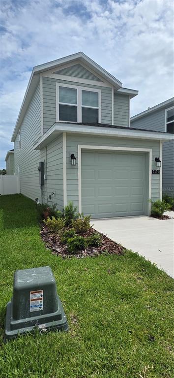 A light green two-story house features a single-car garage and a small landscaped front yard — 7191 SW 92ND STREET, OCALA, FL