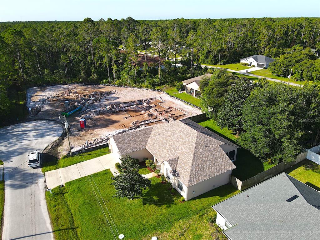 An aerial view shows a residential house with a construction site on the adjacent lot — 16 ZORLOU COURT, PALM COAST, FL