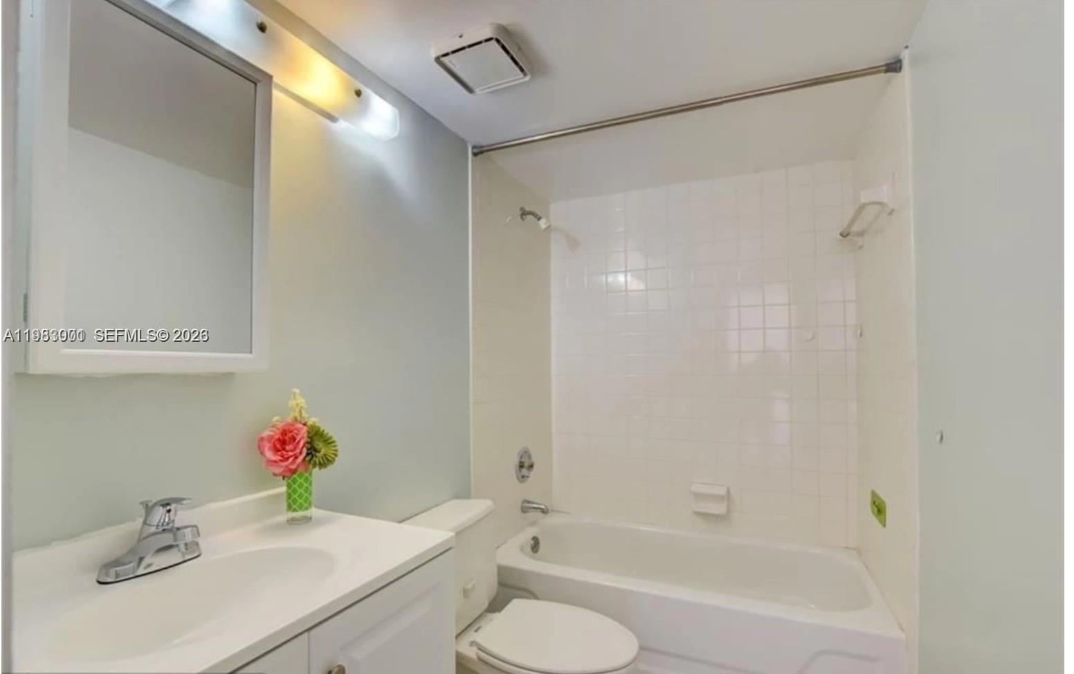 A bathroom features a white vanity, a toilet, and a bathtub with white wall tiles — 3103 Spanish Wells dr # 2A, Delray Beach FL 33445, DELRAY BEACH, FL