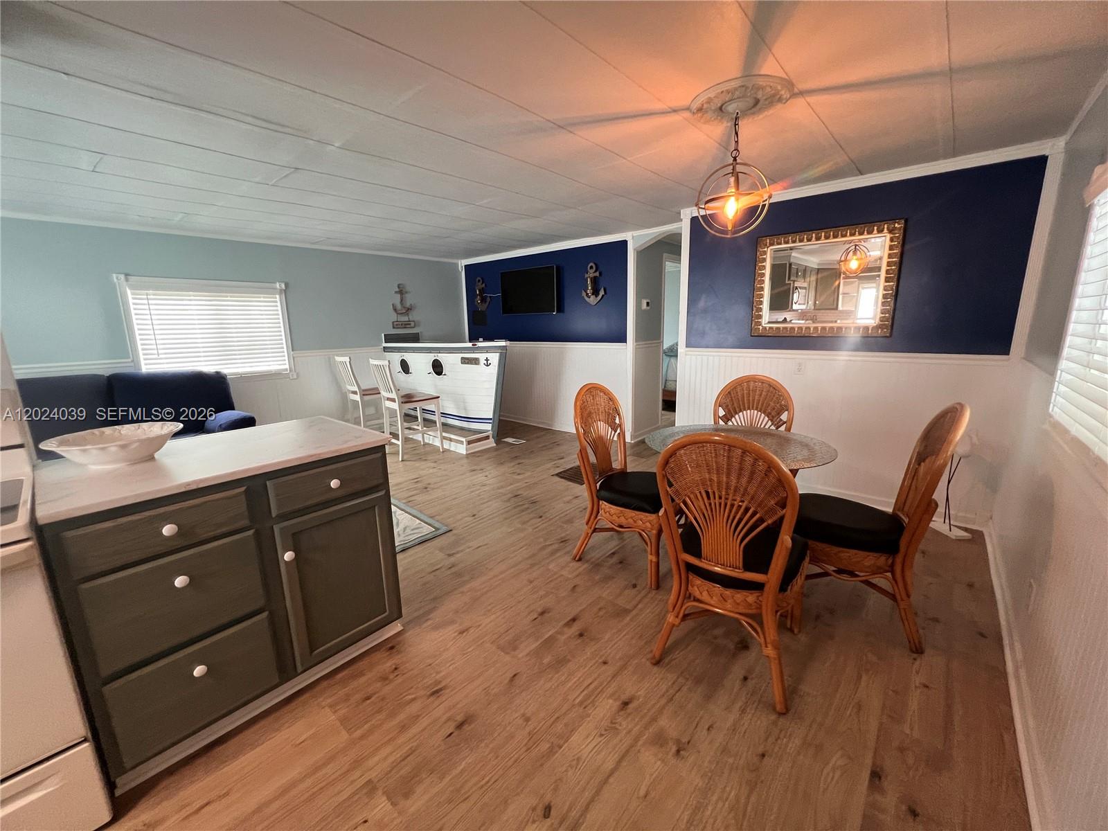 A dining area and kitchen feature a nautical-themed bar, wicker chairs, and dark blue walls — 8709 SW 15th St, Davie FL 33324, DAVIE, FL