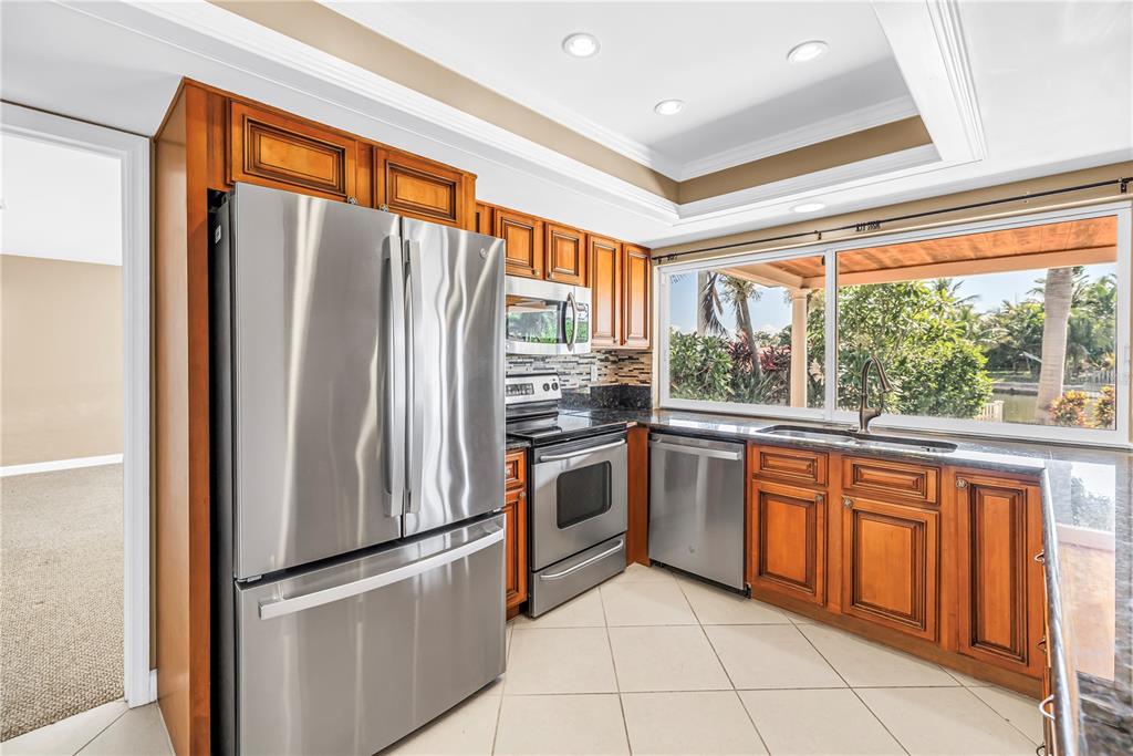 A backyard pool and spa area with a covered patio overlooking a canal at sunset — 1820 TANGLEWOOD DRIVE NE, ST PETERSBURG, FL
