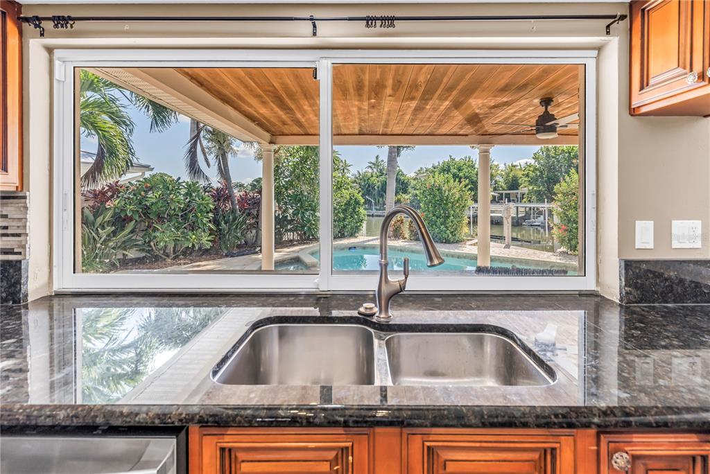A kitchen with wood cabinets, stainless steel appliances, granite countertops, and a large window view — 1820 TANGLEWOOD DRIVE NE, ST PETERSBURG, FL