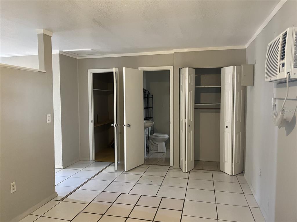 A room with white tile floors, a closet, and a doorway leading to a bathroom — 231 S ORANGE STREET, SEBRING, FL