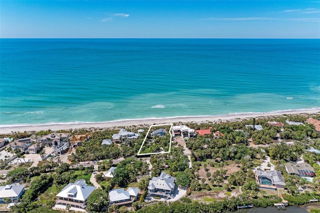 An aerial view shows a beachfront property outlined in white among coastal vegetation and homes — 8270 MANASOTA KEY ROAD, ENGLEWOOD, FL
