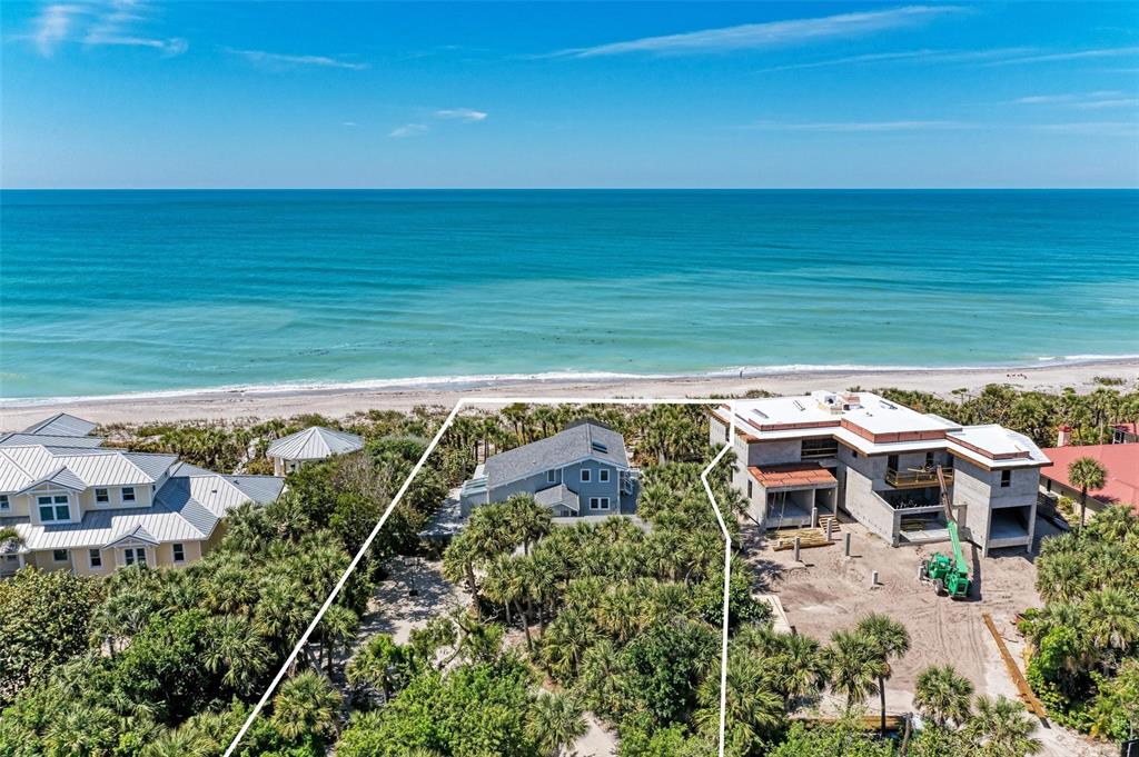 An aerial view shows two houses near a beach, with one home under construction — 8270 MANASOTA KEY ROAD, ENGLEWOOD, FL