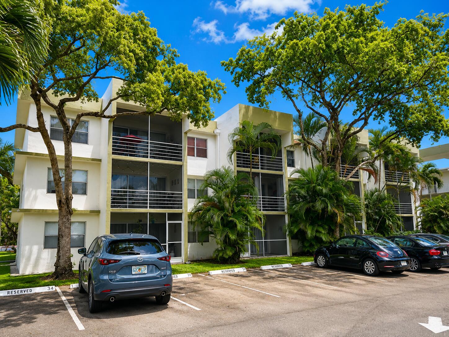 A three-story apartment building with screened balconies and a parking lot in the foreground — 4205 N University Drive # 106, Sunrise FL 33351, SUNRISE, FL
