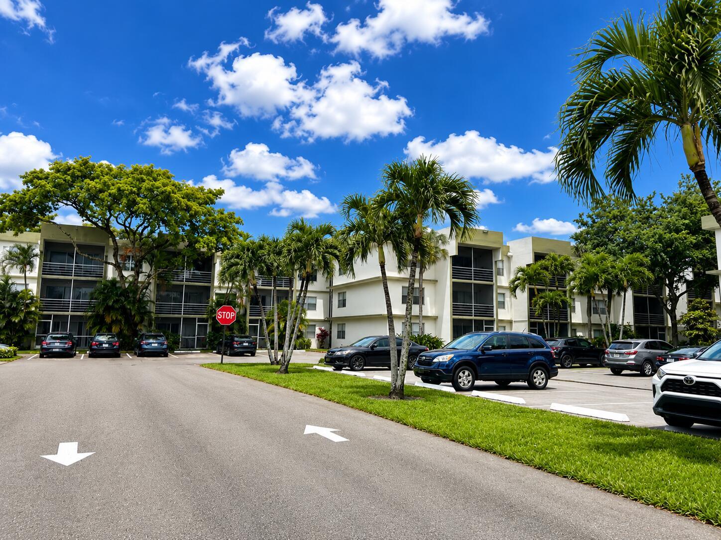 A parking lot sits in front of multi-story apartment buildings surrounded by palm trees — 4205 N University Drive # 106, Sunrise FL 33351, SUNRISE, FL