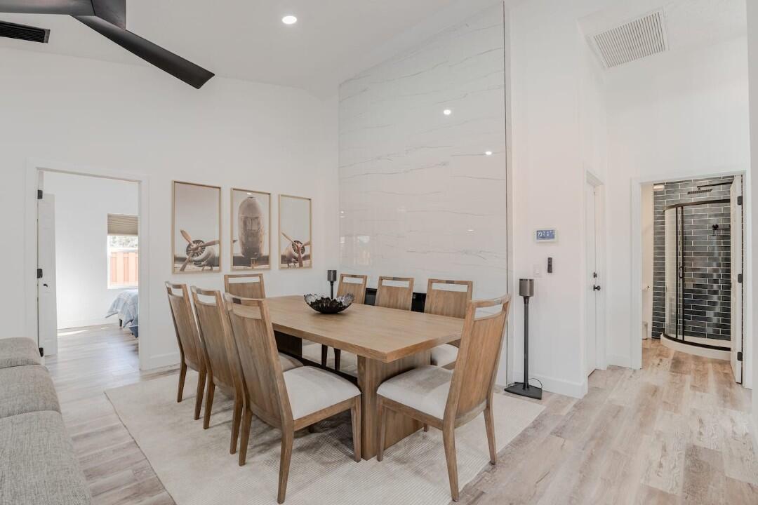 A dining room features a wooden table, six chairs, and a tall marble fireplace surround — 1860 Primrose Lane, Wellington FL 33414, WELLINGTON, FL