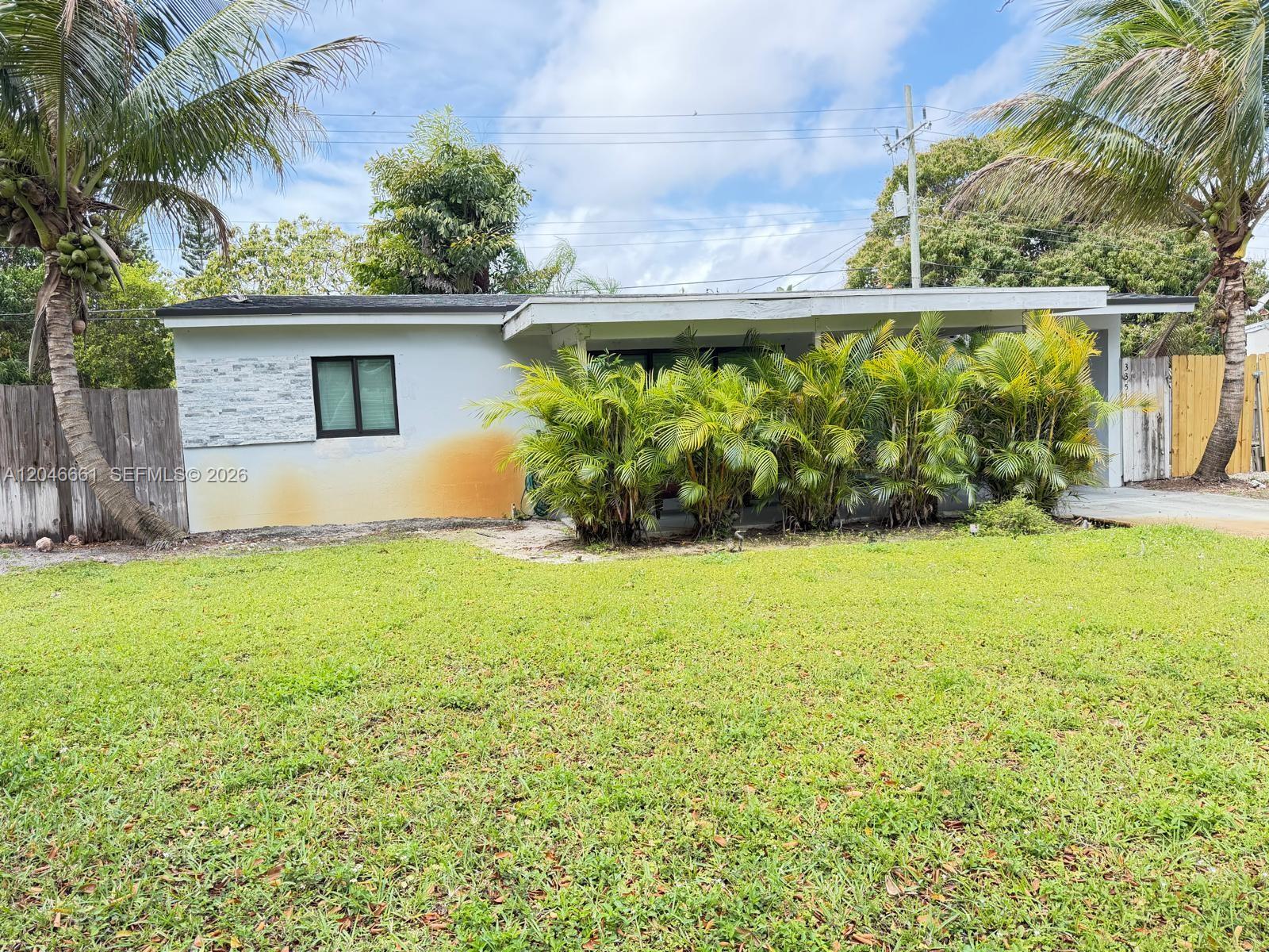 A single-story house with a flat roof, palm trees, and a front lawn — 3351 NE 12th Ter, Pompano Beach FL 33064, POMPANO BEACH, FL