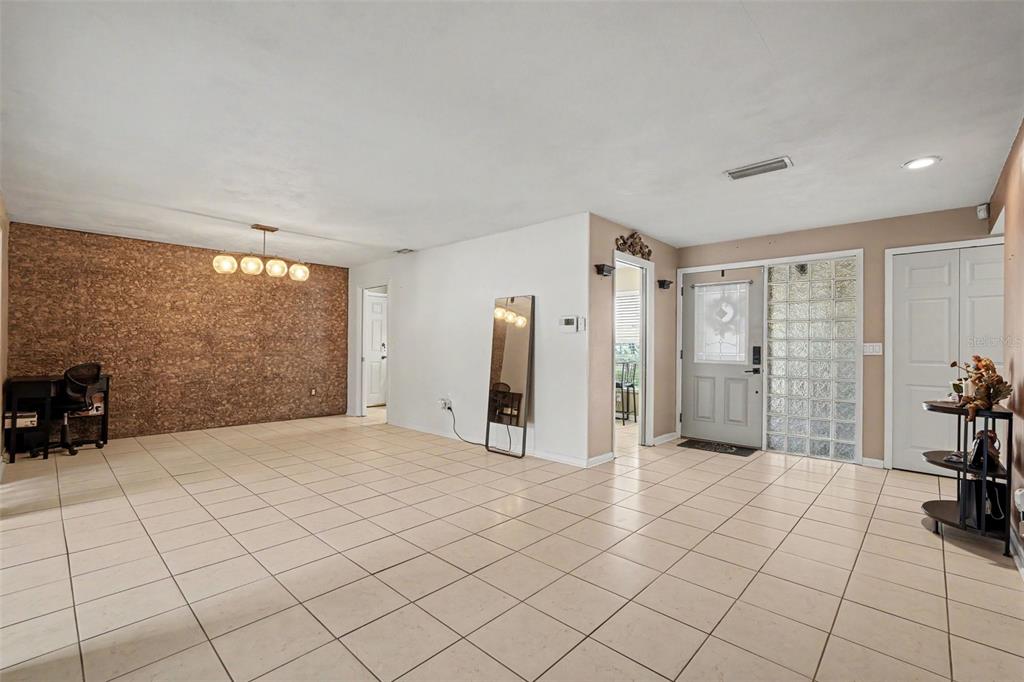 A room with light-colored tile flooring, a textured accent wall, and a glass block window — 5603 LOWN STREET N, ST PETERSBURG, FL