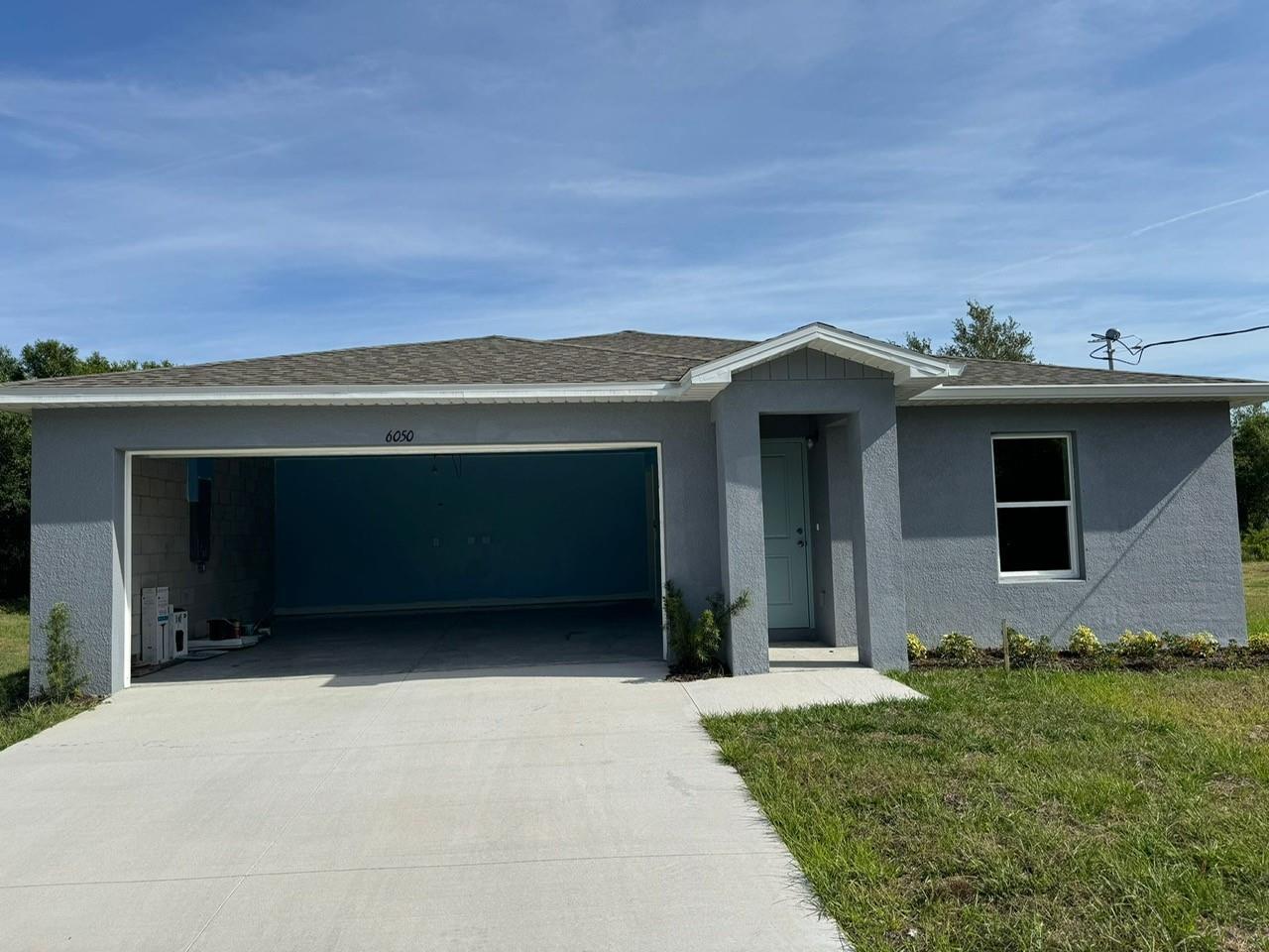 A single-story gray house with a two-car garage and a front entrance under a gable — 6050 Pecan Circle, FL 33935, FL